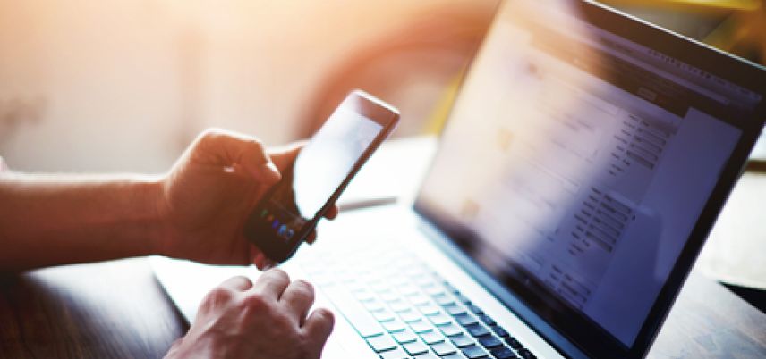 hands using smart phone and laptop