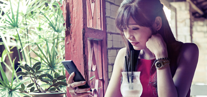 Woman with a drink on phone