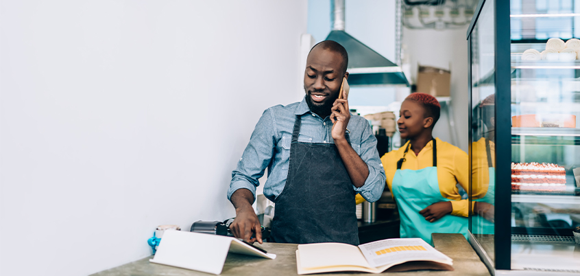 Man with apron looking at tablet