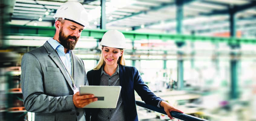 man and woman looking at tablet in a factory