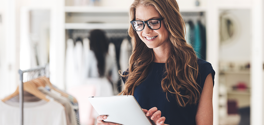Woman with tablet in clothing store