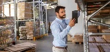 man in warehouse looking at tablet