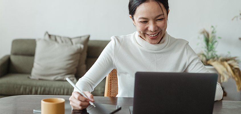 Woman working on laptop and tablet.