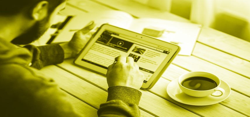 over shoulder view of man using tablet, yellow tint