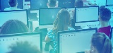 Classroom full of children looking at computer monitors