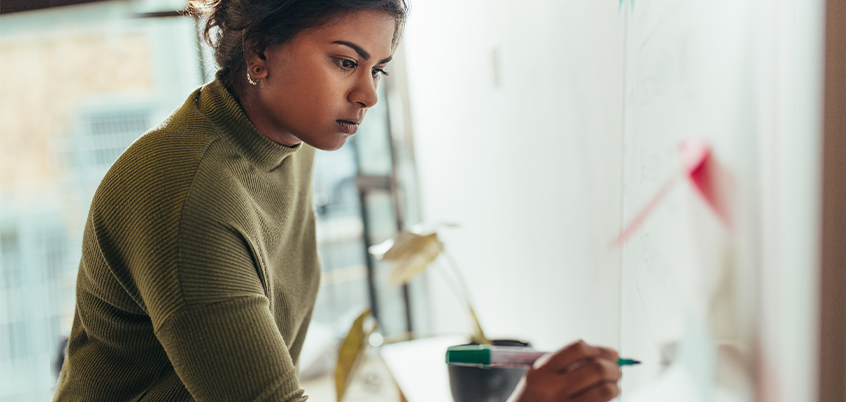 Woman writing on whiteboard