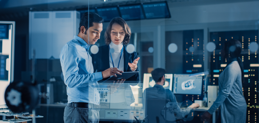 Man and woman in server room looking at tablet