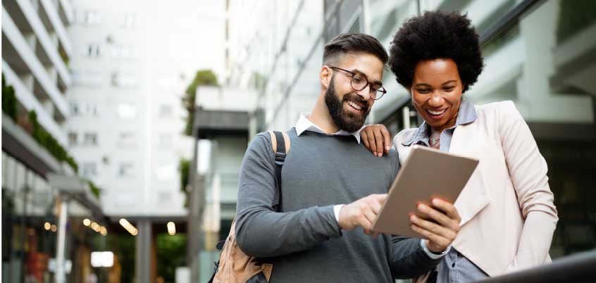 Man and woman outside looking at tablet