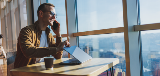 Man Looking Out Window On Phone