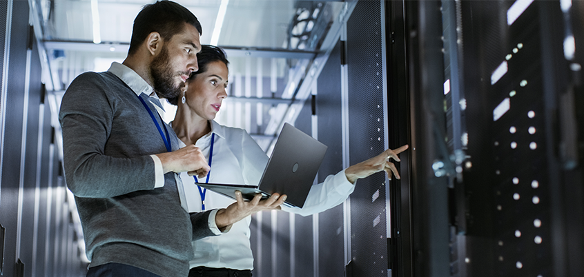 Man and woman in front of server with laptop