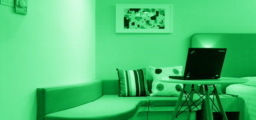 room with laptop on table, green tint over entire image