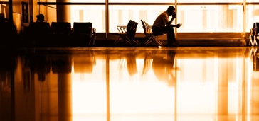 theinternetofthings-innovationtoimproveguestexperienceenhanceoperations people in waiting area at the airport, orange-gold tint