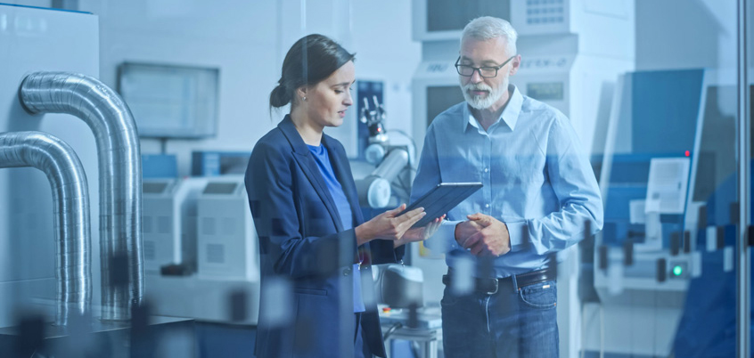 Engineer And A Project Manager Standing In A Workshop