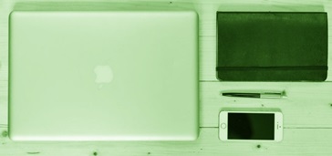 what-mobile-apps--different-paths-to-mobile-app-adoption overhead shot of laptop, smartphone, notebook, and pen on table, green tint
