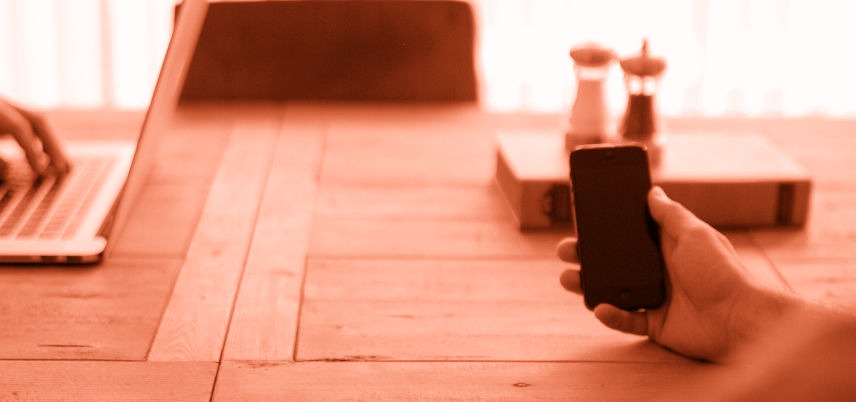 hand holding smartphone, orange tint